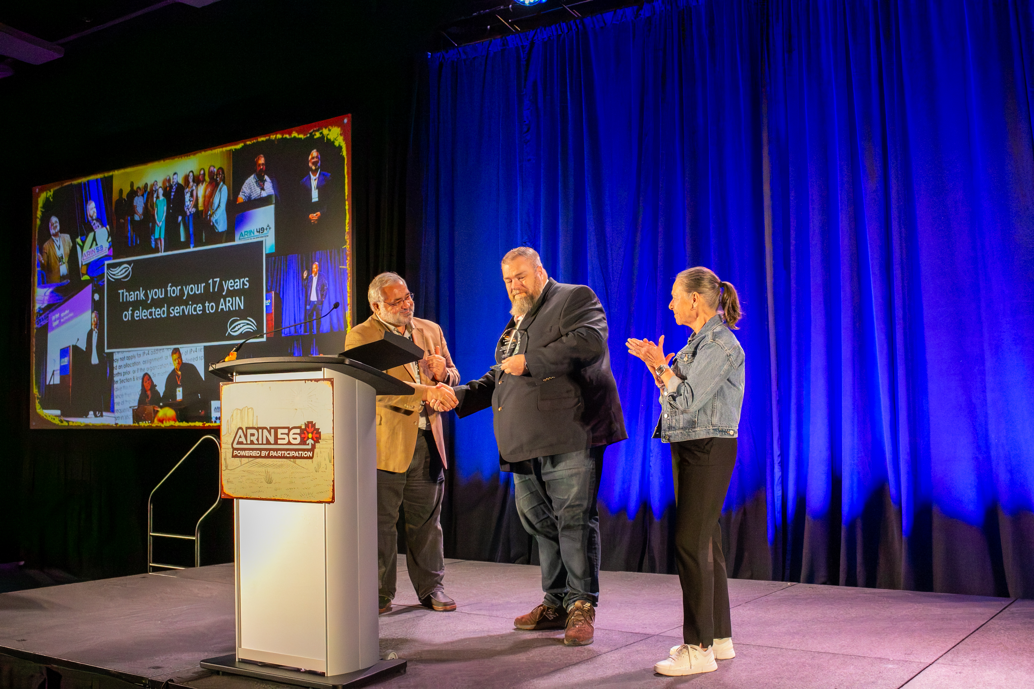 John Curan and Nancy Carter present a commemorative plague to Bill Sandiford